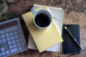 Tastatur neben einer Tasse Kaffee und Schreibblock