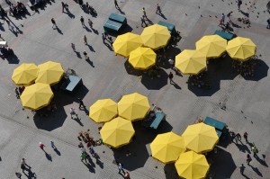 Menschen unter gelben Marktschirmen